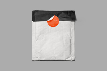 Crumpled white envelope sealed with a bright orange sticker and black flap, set on grey background. Great for branding mockups, mailing templates, or retro packaging design.