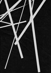 Angular white paper strips crossing each other over a black backdrop. Modern abstract composition with sharp line movement and intersecting points.