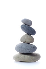Fototapeta premium Natural stacked smooth stones in a balanced arrangement isolated on white background