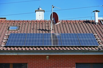 Family house with solar panels on the roof. Home photovoltaic power plant. Concept for industry and green cheaper electricity from renewable sources.