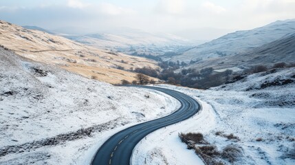 Snowy mountain pass winding road in winter landscape.