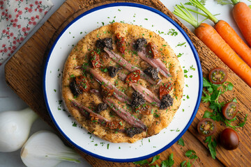 Authentic Italian focaccia with salted anchovies, sun-dried tomatoes, and black olives. Top view table with christmas decorations.