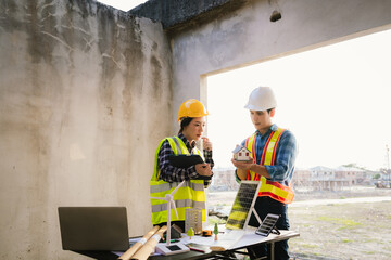 Architects and engineers collaborate at a desk with blueprints and solar panels, planning...