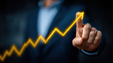 Businessman pointing at a rising graph symbolizing success and growth.