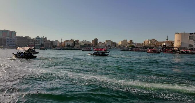 Boats floating on Dubai Creek with skyline in background