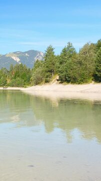 Scenic view of Urisee near Reutte in Tirol with crystal clear turquoise water, forested slopes, and calm mountain serenity