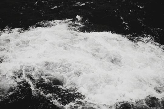 Foamy white water erupts from dark sea.  Detailed view of waves crashing