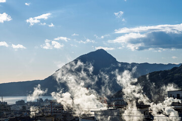 Beppu cityscape with Steam drifted from public hot spring baths and ryokan onsen background, Beppu,...