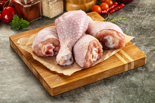 Raw uncooked chicken drumsticks over board