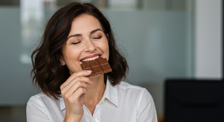 Woman enjoying delicious dark chocolate bar