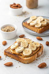 Delicious Peanut Butter Banana Toast with Almonds on White Background