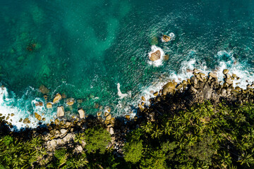 Aerial view Top down seashore, Waves crashing on rocks cliff, Beautiful sea surface in sunny day summer background, Amazing seascape top view seacoast at Phuket Thailand
