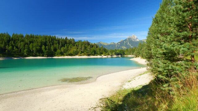 Austrian lake Urisee with calm turquoise water and natural beach near Reutte Tirol, scenic alpine escape for summer relaxation