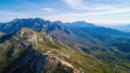 Naklejka premium Aerial view of a vast mountain range, showcasing rugged peaks, verdant slopes, and a clear blue sky. The landscape stretches into the distance, revealing layers of hills and valleys. : Generative AI
