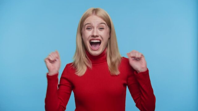 Overjoyed woman celebrating with excitement on blue background