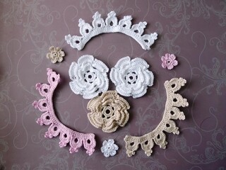 An elegant lace crown reigns center stage, surrounded by delicate roses and blooms—a feminine...