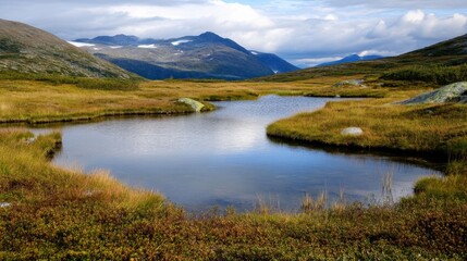 Serene mountain lake nestled amidst autumnal tundra, reflecting the majestic peaks under a partly cloudy sky.  A tranquil scene of natural beauty. : Generative AI