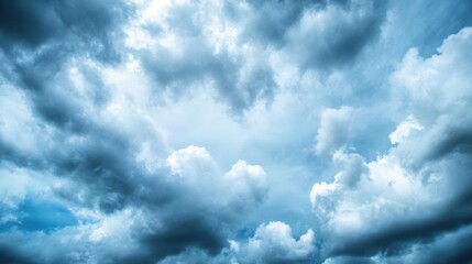 Fototapeta premium A dramatic sky filled with voluminous, dark blue and light blue cumulus clouds, creating a moody and atmospheric scene. : Generative AI