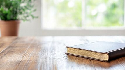 A closed brown leather-bound book with gold gilded edges rests on a rustic wooden table near a blurred window and potted plant. : Generative AI