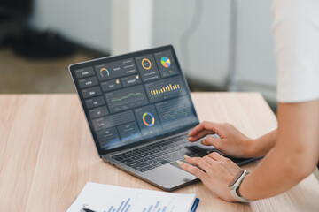 Person analyzing data dashboard, business analytics, financial chart, and performance graph on laptop, working at office desk with report, modern technology, and professional focus