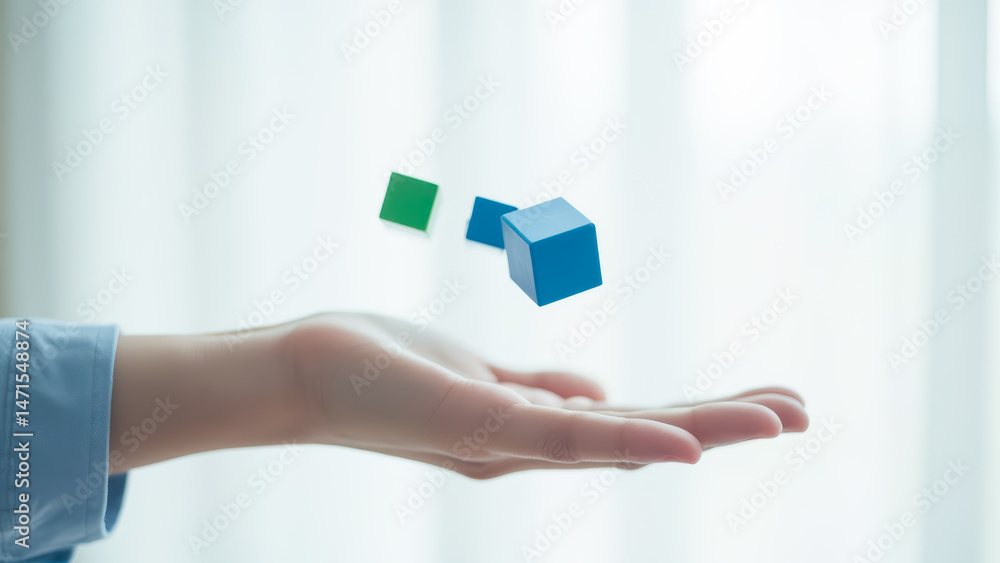 Aufkleber hand releasing colorful building blocks in a bright and soft light environment