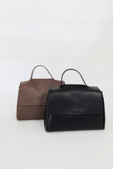 Black, white and brown handbags on light background