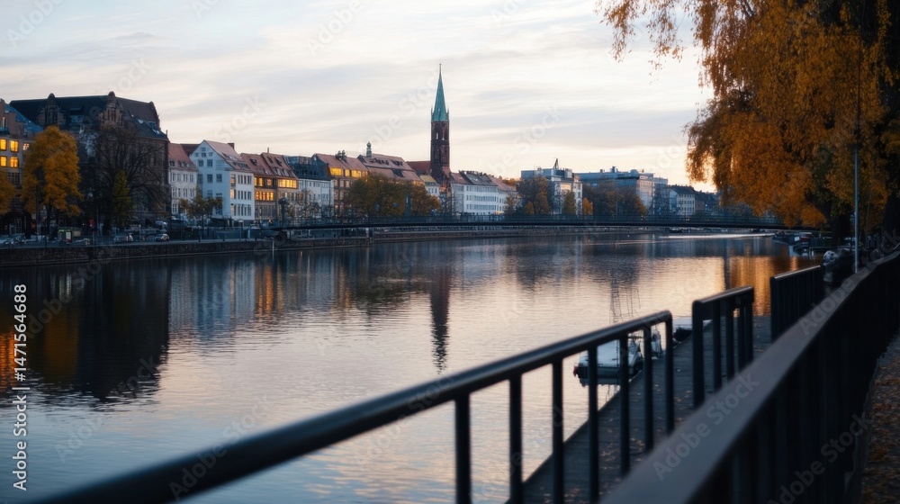 Aufkleber serene autumn evening view of a river reflecting illuminated buildings and a church spire, with a ca