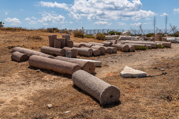 Red granite columns on the ground at Caesarea National Park in Caesarea, Israel.
