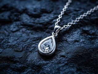 Elegant teardrop diamond pendant necklace on a dark textured background.