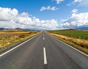 Endless Straight Road Under Blue Sky with Fluffy White Clouds
