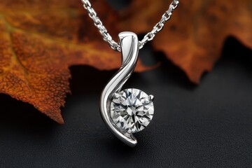 Elegant diamond pendant necklace with a silver chain, set against a dark background and autumn leaves.