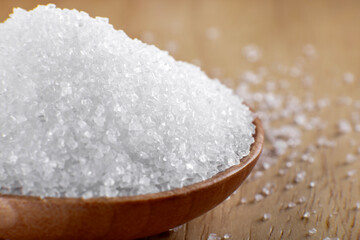 Crystal clear white sugar crystals macro close-up, spoon and wooden cutlery
