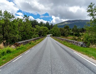 Scenic Empty Road Through Lush Green Landscape Under Cloudy Sky