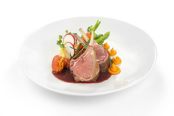 Gourmet rack of lamb with vegetables and sauce on white plate