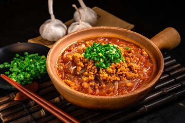 Spicy minced pork and rice noodles, tableware made of earthenware, kitchen background