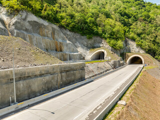 Aerial view of a quiet highway passing through a tunnels in a picturesque hilly region Rikoti Pass