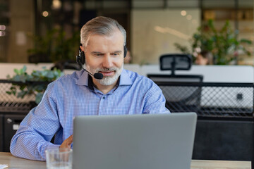 Smiling friendly handsome middle aged male call center operator.