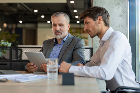 Two business men talking to each other discussing their business proposal.