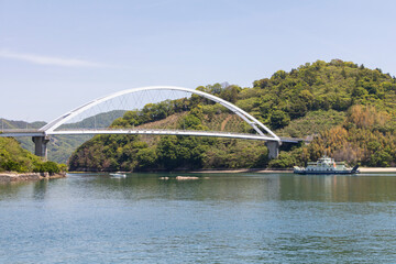 中の瀬戸大橋を航行するフェリー
