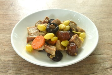 deep fried tofu and gluten with yellow ginkgo and pickled jujube couple black mushroom in soy sauce vegetarian food on plate 