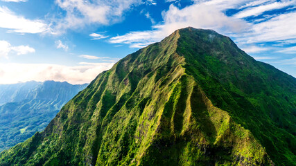 Impressive verdant rock in the sunlight. Drone footage distancing from a mountain in Hawaii, USA.