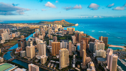 Fototapeta premium Beautiful luxurious Waikiki resort with green park in the middle. Ala Wai Canal and Pacific Ocean surround the area. Diamond Head Crater at backdrop.