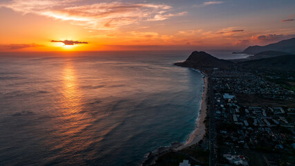 Bright orange light is on the waterscape. Dusk time over the shore of Oahu, Hawaii, USA. Aerial...