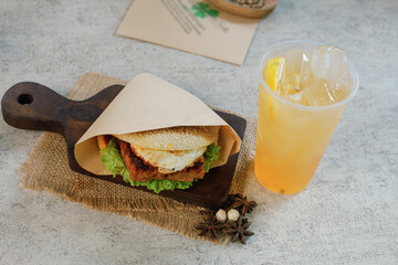 Sandwich with chicken and cheese on a wooden board with ice