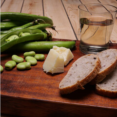 Merenda con formaggio, fave, pane e bicchiere di vino