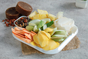 Mixed fruits and vegetables in a white bowl on the table