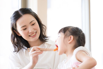子どもの食事を食べさせる母親　あ～ん　子どもの食育などのイメージ