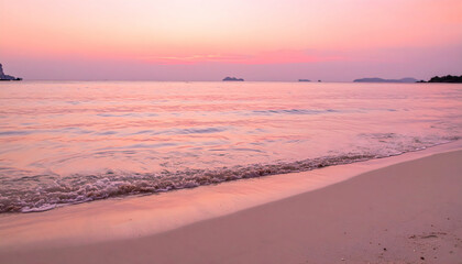 Obraz premium Pink Sunset Beach: Serene pink hues paint the sky and sea at sunset, gentle waves lap the pristine sandy beach, creating a tranquil and romantic atmosphere.