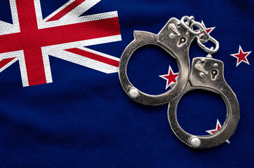 Flag of New Zealand and police handcuffs. Crime and offenses in country Concept
