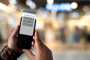 Businessman typing on laptop with contact us icons overlay. Concept of customer support, communication, and digital contact service for business or corporate websites.